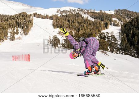 Beautiful beginner snowboarder girl in caucasian mountains