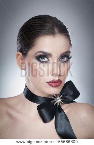 Hairstyle and Make up - beautiful female art portrait with black ribbon. Elegance. Genuine Natural brunette with ribbon - studio shot. Portrait of a attractive woman with beautiful eyes and red lips