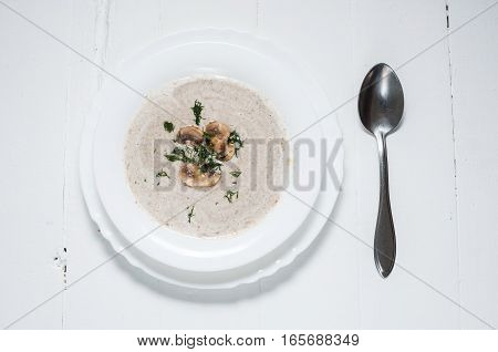 Bowl of creamy mushroom soup on wood.
