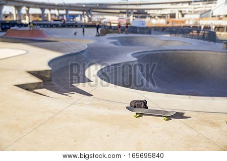 skateboard and backpack in skate park. the concept of freestyle extreme sport. blurred background due to the concept. empty space for your text
