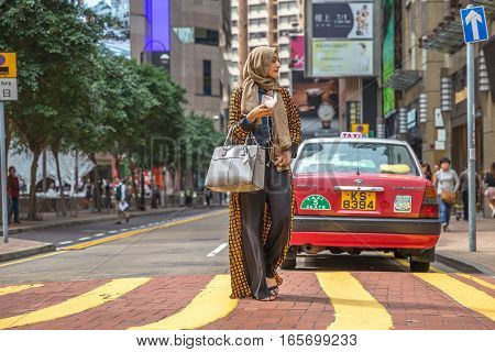 Hong Kong, China - December 6, 2016: elegant beautiful woman arab clothing with mobile in hand in Causeway bay, one of the most attractive areas for tourists and business people and good for shopping.
