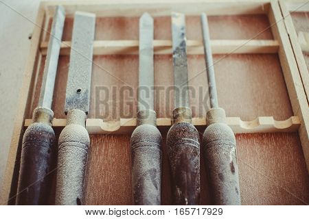 Old used wood lathe chisels selection on the dark wooden table, selective focus