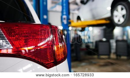 Automobile service - two mechanics standing near lifted automobile, slider