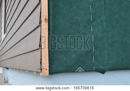 Close up on corner thermal insulation of a house wall on a building site. Construction or repair of the rural houseplastic siding fixing facade membrane insulation house wall.