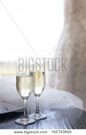 Two glasses of champagne near the wedding veil