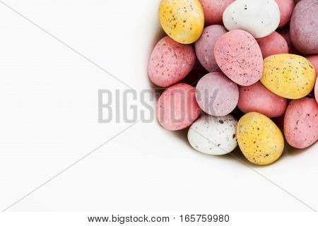 Easter chocolate candy eggs on white background top view blank space for text