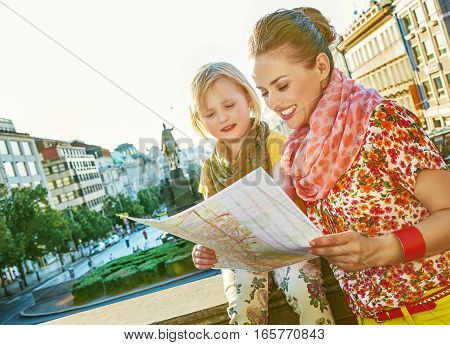 Mother And Daughter Tourists Looking At The Map In Prague