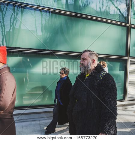 MILAN ITALY - JANUARY 17: Fashionable people gather outside Armani fashion show building during Milan Men's Fashion Week on JANUARY 17 2017 in Milan.