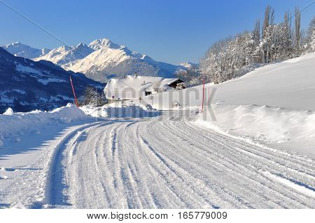 snowy road going to a village in mountain