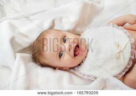 sweet happy little girl lying in bed