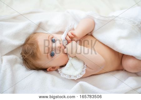 sweet happy little girl lying in bed