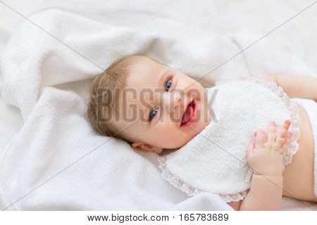 sweet happy little girl lying in bed