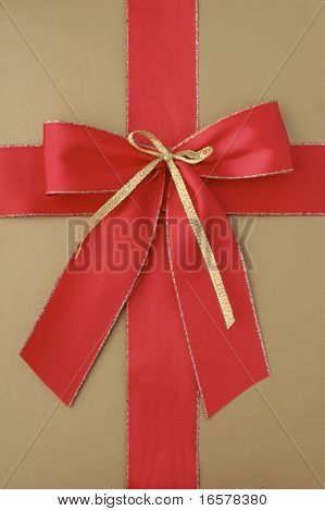 Close-up of a classic giftbox in gold and with a red ribbon