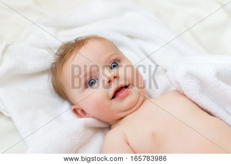 sweet happy little girl lying in bed