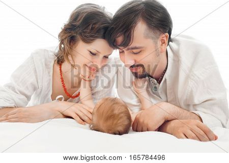 Happy family, mother, father and daughter resting on the white bed