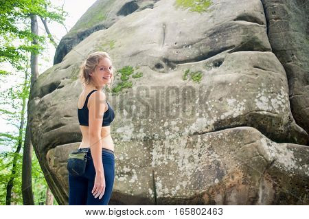 Young Woman With Climbing Equipment In Front Of A Stone