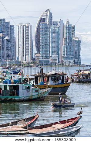 June 15, 2016 Panama City, Panama: small fishing boats floating on the water by the fish market with the modern downtown highrise buildings in the background the fish market with the modern downtown highrise buildings in the background