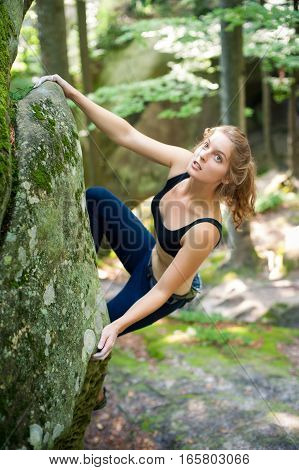 Young Woman Climbing On Large Boulders Outdoor