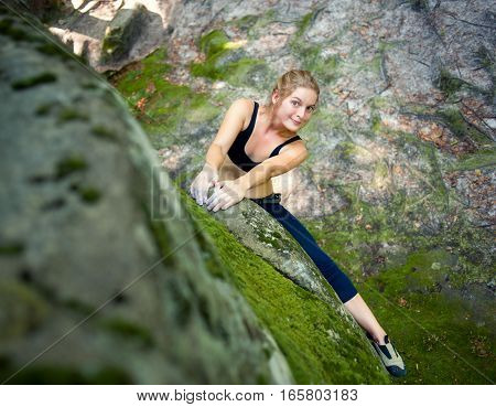 Young Woman Climbing On Large Boulders Outdoor