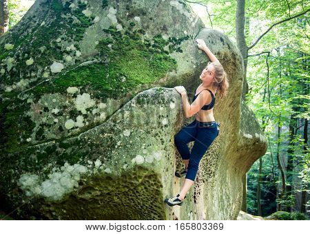Young Woman Climbing On Large Boulders Outdoor