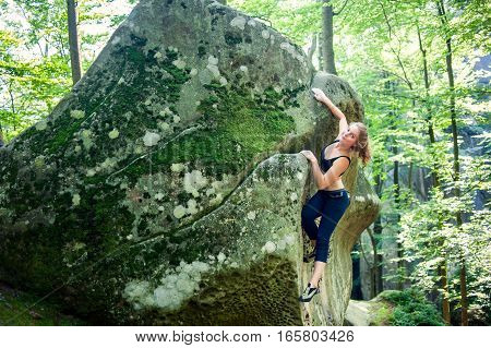 Young Woman Climbing On Large Boulders Outdoor