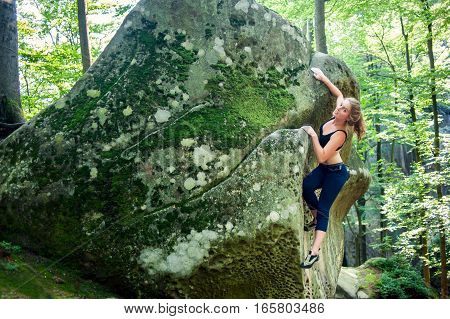 Young Woman Climbing On Large Boulders Outdoor