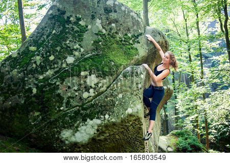 Young Woman Climbing On Large Boulders Outdoor