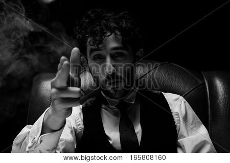 Businessman with smoking gun finger red. red chair on a black background