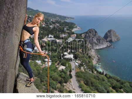 Female Climber Climbing With Rope On A Rocky Wall