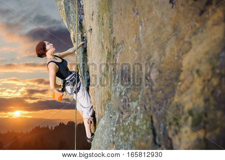Female Climber Climbing With Rope On A Rocky Wall