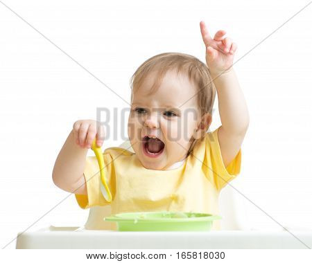 Baby girl eating her dinner isolated on white background