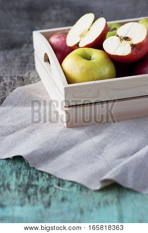 Fresh apples in a tray on a wooden background. Apples are red, green, yellow. Healthy Eating Vitamins Vegetarian Seasonal harvest.
