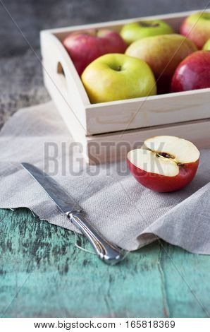 Fresh apples in a tray on a wooden background. Apples are red, green, yellow. Healthy Eating Vitamins Vegetarian Seasonal harvest.