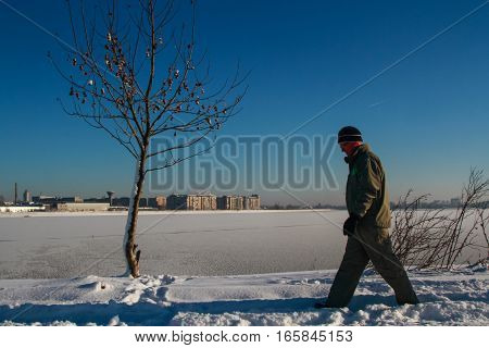 Bucharest Romania January 1 2015: A man walks on the edge of a lake in Bucharest during a cold winter day.