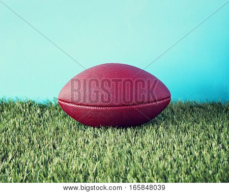 Vintage football over grass and blue background