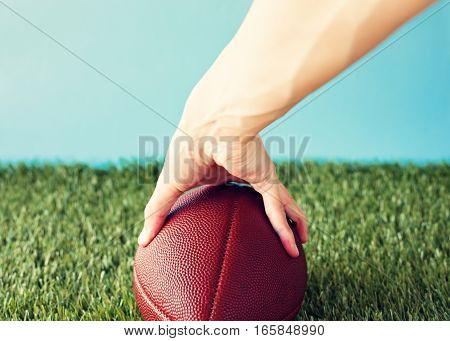 Vintage football over grass being held prior to snap