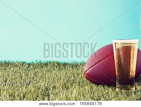 Vintage football over grass and beer glass