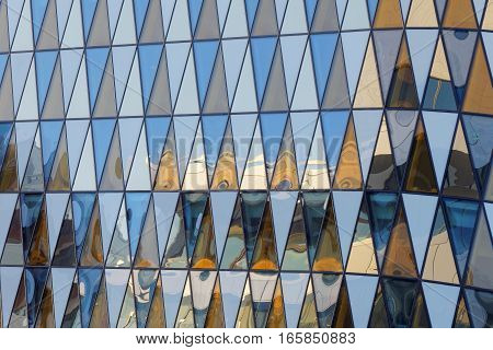 Colorful fasade made of triangles of different colors orange blue and white