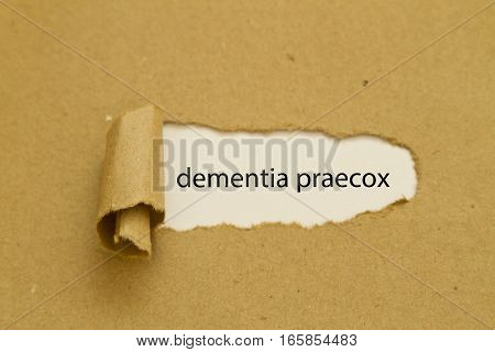 dementia praecox word written under torn paper.