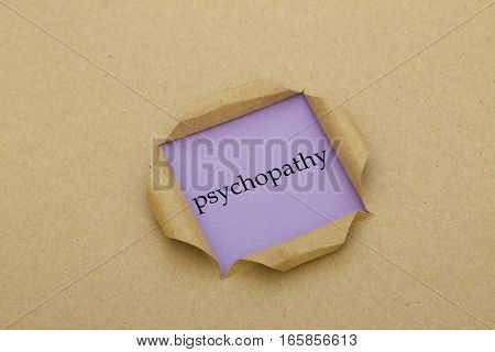 psychopathy word written under torn paper .
