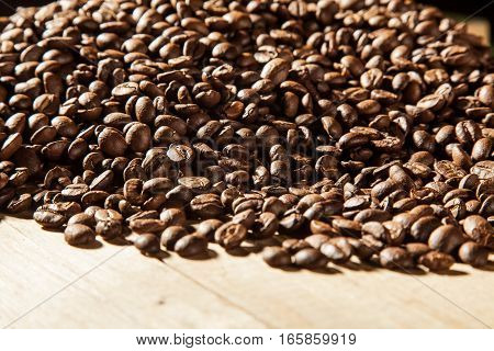 Roasted coffee beans on wood background. Detailed close up