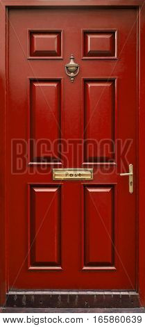 Classical red door isolated with postbox and knocker and handle