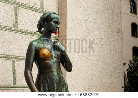 Juliet capulet statue in munich germany july 2015 with shiny breast and deep red flower behind her ear