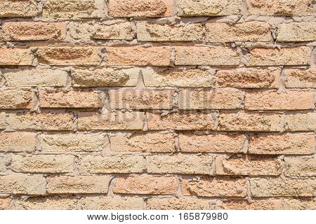 Salmon coloured rough grunge brick pattern on wall