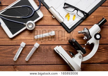 doctor workplace at wooden table with microscope in lab top view no one