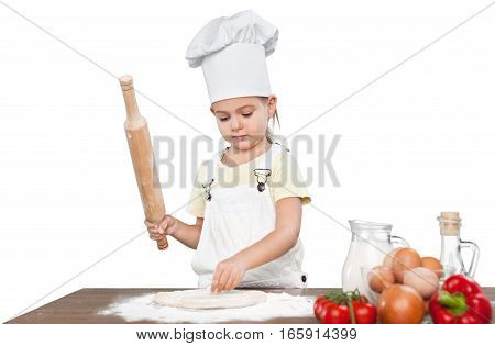 Happy little chef smeary with flour stretching the dough