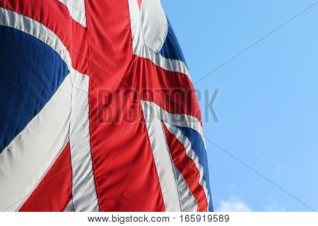 UK Union flag, also known as the Union Jack, set against blue sky copy space.