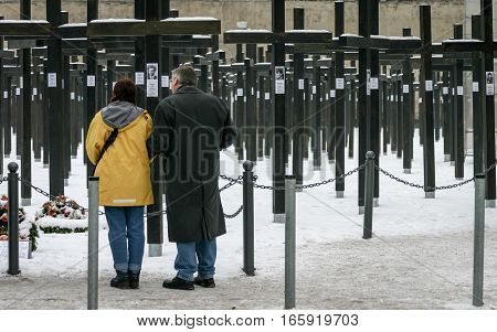 Berlin Germany - January 30 2005: a mature couple take a moment to reflect at the old Freedom Memorial paying their respects to the victims of the Berlin Wall. the memorial was dismantled in July 2005.