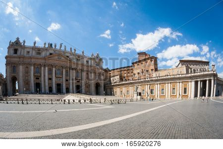 A super-wide fish-eye view of the popular tourist attraction St. Peter's Square in the Vatican City with the Basilica and Popes palace creating a background to the tourists and pilgrims.