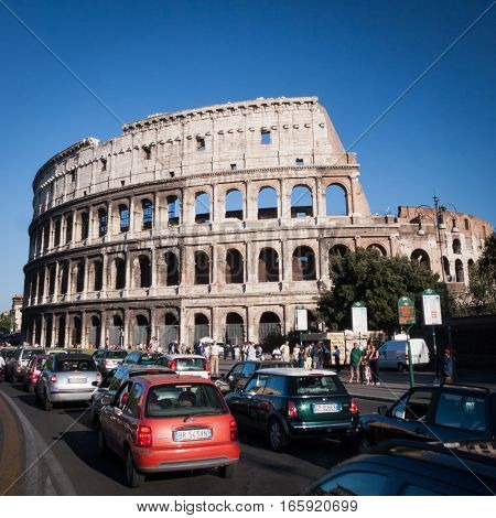 Rome Italy - 5 August 2005: A daytime view of the Colosseum in Rome Italy with heavy traffic and bustling with tourists.